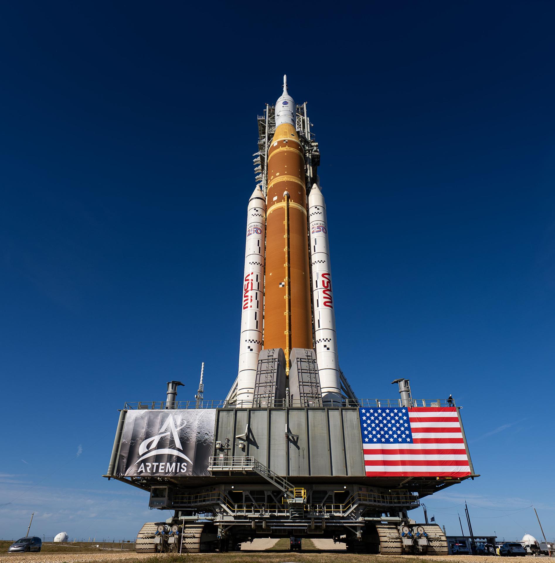 This image shows NASA’s SLS (Space Launch System) and Orion spacecraft rolling out of the Vehicle Assembly Building at NASA’s Kennedy Space Center. NASA's massive Crawler-Transporter, upgraded for the Artemis program, carries the powerful SLS rocket and Orion spacecraft on the Mobile Launcher from the Vehicle Assembly Building to Launch Pad 39B at Kennedy Space Center in preparation for the Artemis II mission.